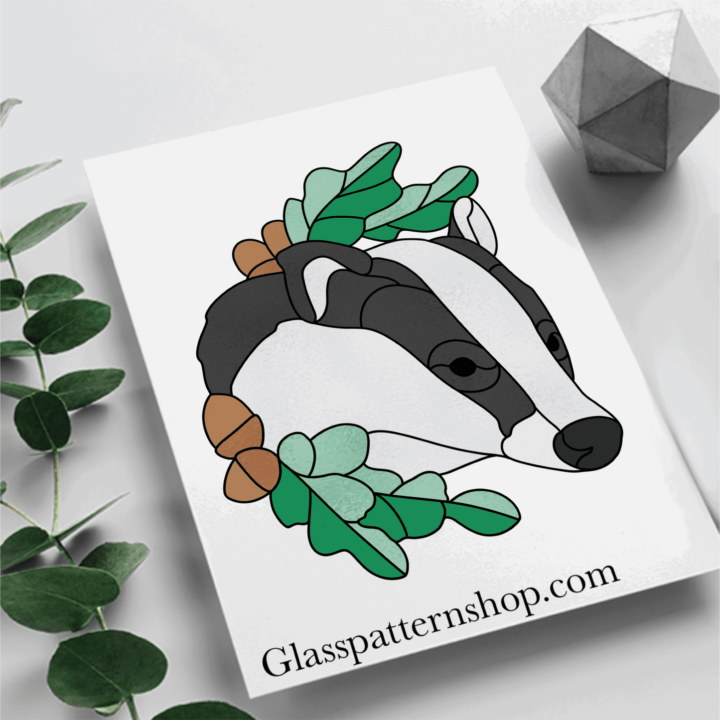 Stained glass pattern featuring a detailed badger surrounded by autumn leaves and acorns. Perfect for creating woodland-themed glass art.