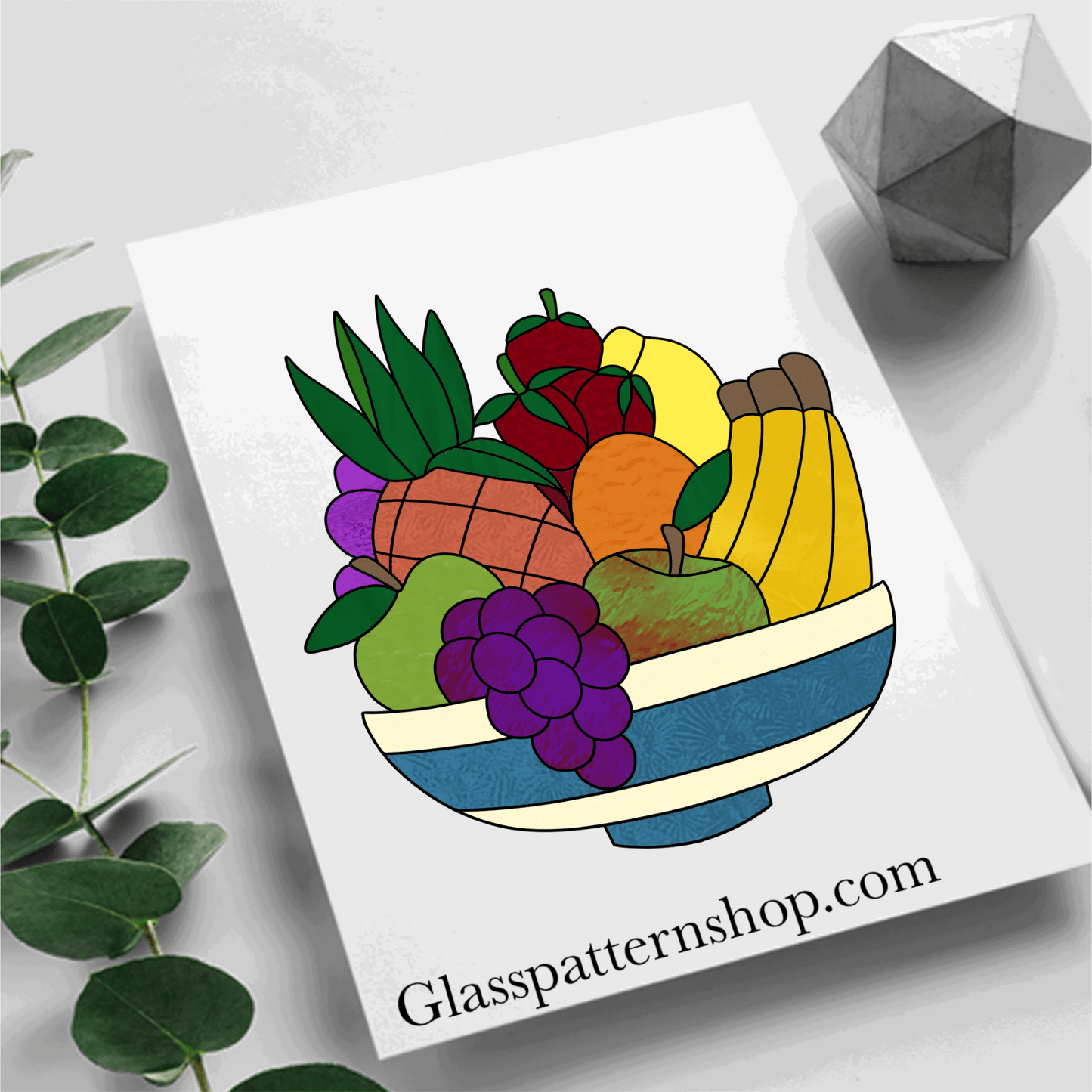 A stained glass pattern featuring a decorative bowl filled with fruits such as apples, oranges, grapes, and bananas, designed for vibrant and customisable stained glass projects.